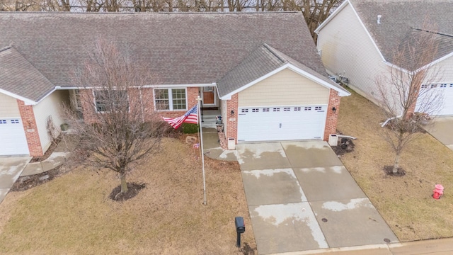 view of front of house with a garage, concrete driveway, a shingled roof, and brick siding