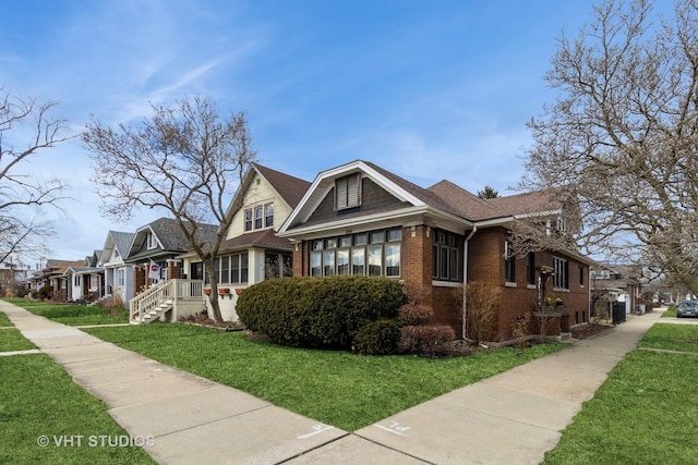 view of front of house featuring brick siding, a front lawn, and a residential view