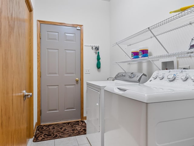 laundry room featuring laundry area, light tile patterned flooring, and washing machine and clothes dryer