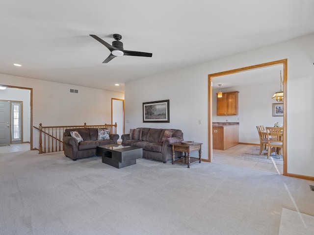 living area with recessed lighting, light colored carpet, visible vents, and baseboards