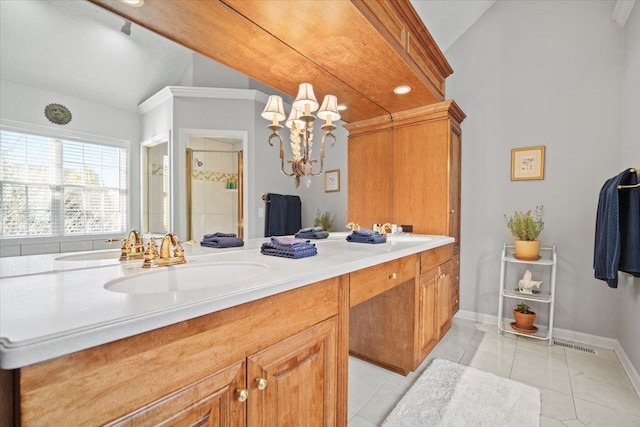 bathroom featuring vaulted ceiling, a sink, a shower stall, baseboards, and tile patterned floors