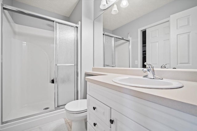 full bathroom with toilet, a textured ceiling, a shower stall, and vanity