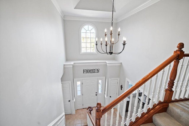 entrance foyer featuring baseboards, ornamental molding, stairway, an inviting chandelier, and a high ceiling