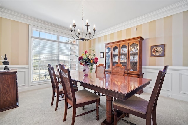 dining space with light carpet, a wainscoted wall, a notable chandelier, and wallpapered walls