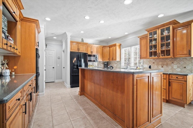 kitchen featuring backsplash, black appliances, brown cabinetry, glass insert cabinets, and crown molding