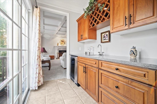 kitchen featuring wine cooler, coffered ceiling, a sink, and a wealth of natural light