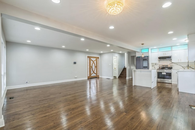 unfurnished living room with dark wood-style floors, stairs, baseboards, and recessed lighting