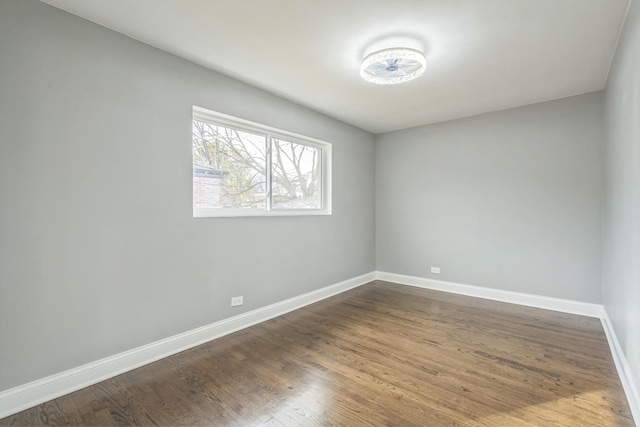 unfurnished room with baseboards and wood finished floors