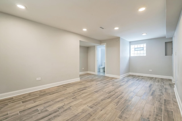 below grade area featuring light wood-style floors, recessed lighting, and baseboards