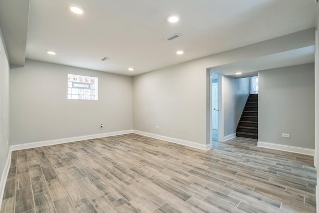 below grade area with light wood finished floors, stairs, visible vents, and recessed lighting