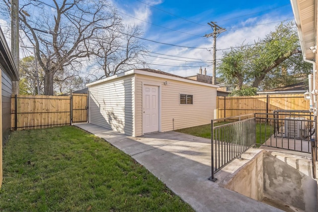 view of outdoor structure with an outdoor structure, a fenced backyard, and a gate