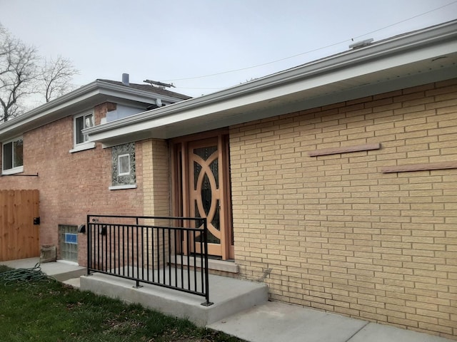 view of exterior entry featuring brick siding