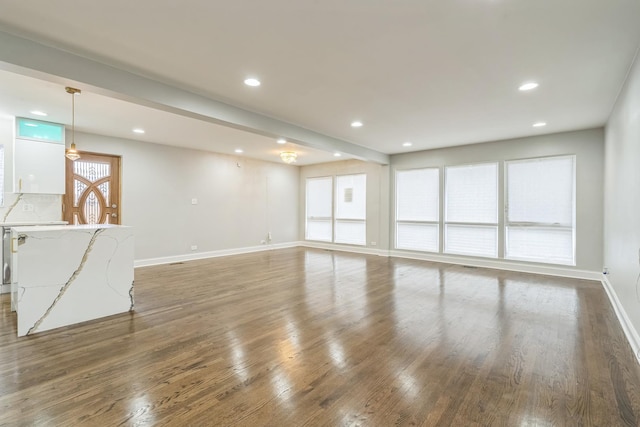 unfurnished living room with baseboards, dark wood-type flooring, and recessed lighting