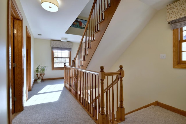 hallway featuring carpet, visible vents, and baseboards