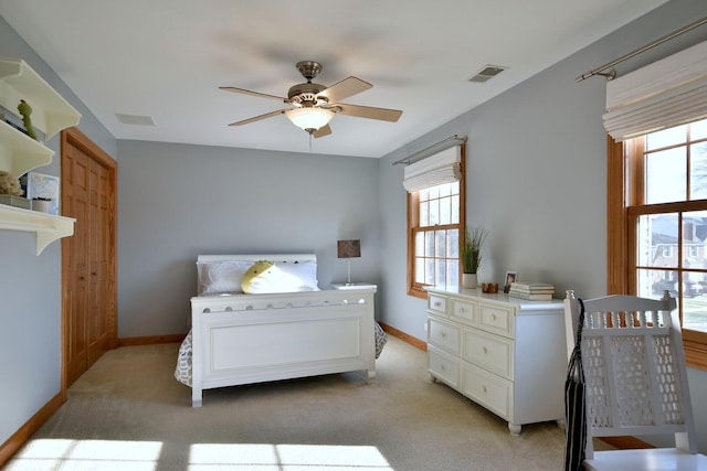 bedroom featuring a ceiling fan, light colored carpet, visible vents, and baseboards