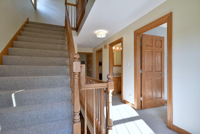 stairway featuring carpet floors and baseboards