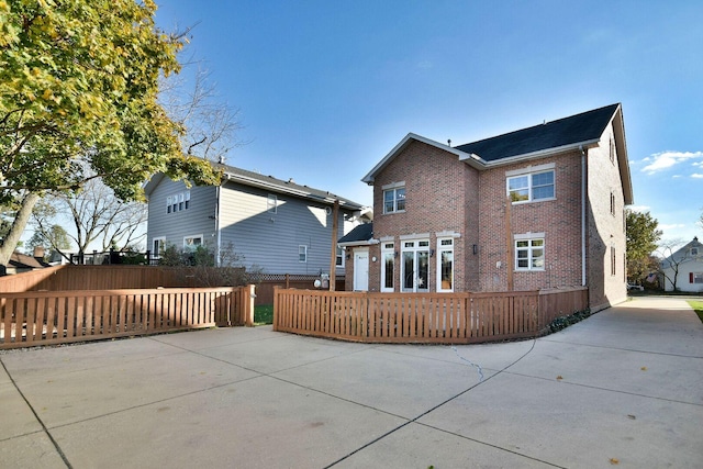 rear view of house with brick siding and fence