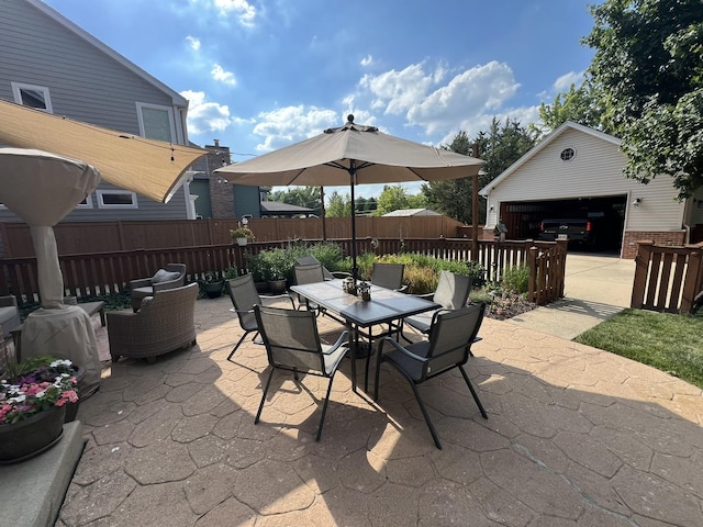 view of patio featuring outdoor dining space, fence, and an outbuilding