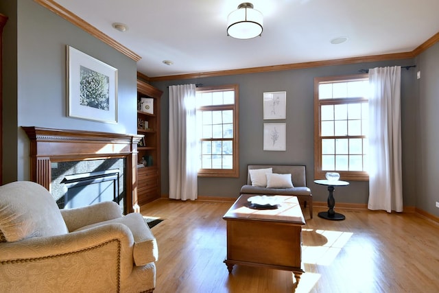 living area featuring ornamental molding, a high end fireplace, and plenty of natural light