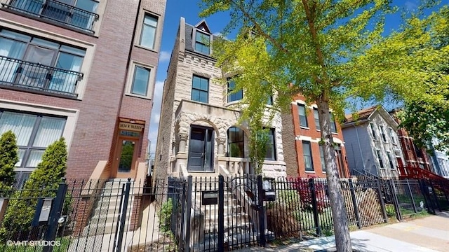 view of front of property featuring brick siding and a fenced front yard