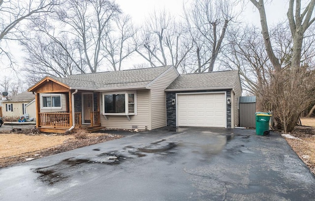 view of front of house featuring a garage, aphalt driveway, and a shingled roof