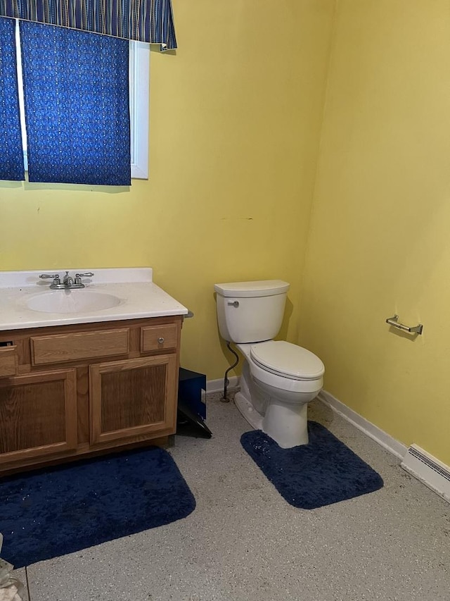 bathroom featuring toilet, baseboards, baseboard heating, and vanity