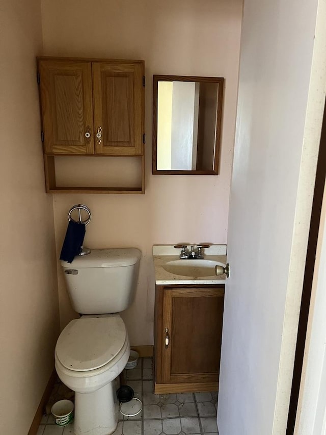 bathroom with baseboards, vanity, and toilet