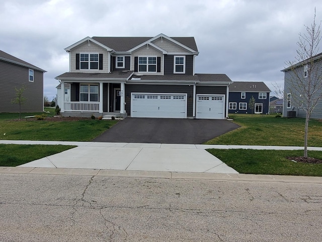 view of front of property featuring central air condition unit, aphalt driveway, a garage, and a front lawn