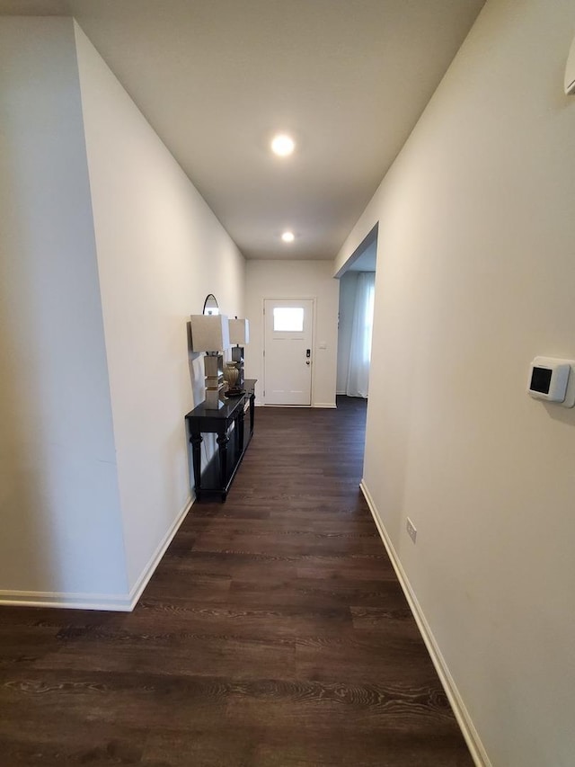 hallway with baseboards, recessed lighting, and dark wood-type flooring