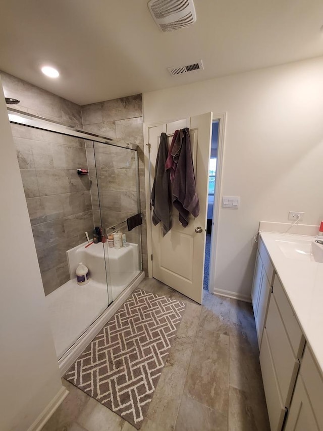 full bath with vanity, a shower stall, baseboards, and visible vents