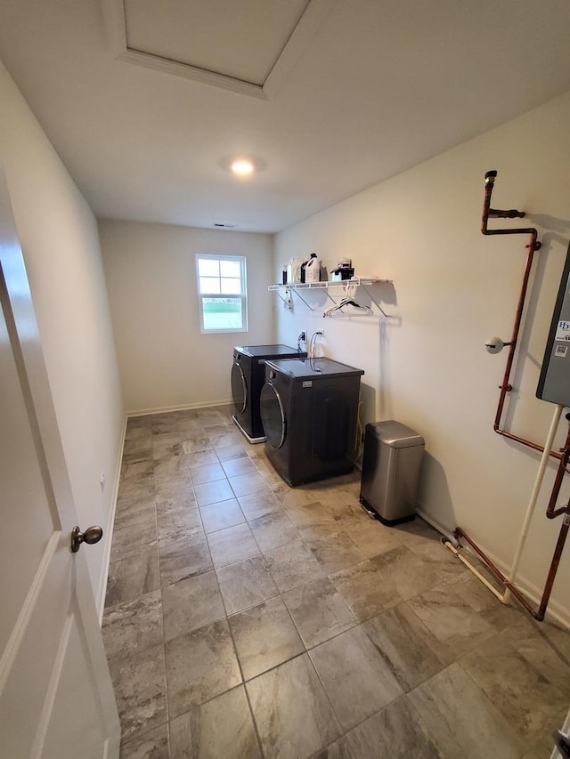 clothes washing area featuring baseboards, washer and dryer, and laundry area