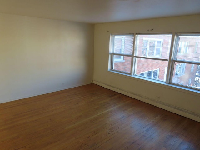 empty room with wood finished floors and baseboards