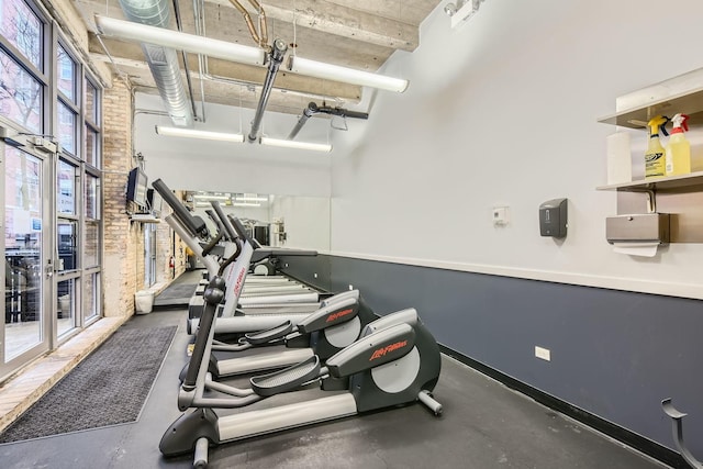 exercise room featuring a towering ceiling