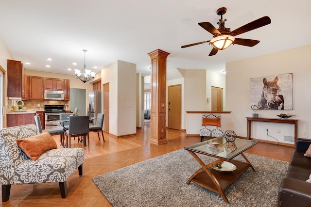 living area featuring recessed lighting, ornate columns, visible vents, baseboards, and ceiling fan with notable chandelier