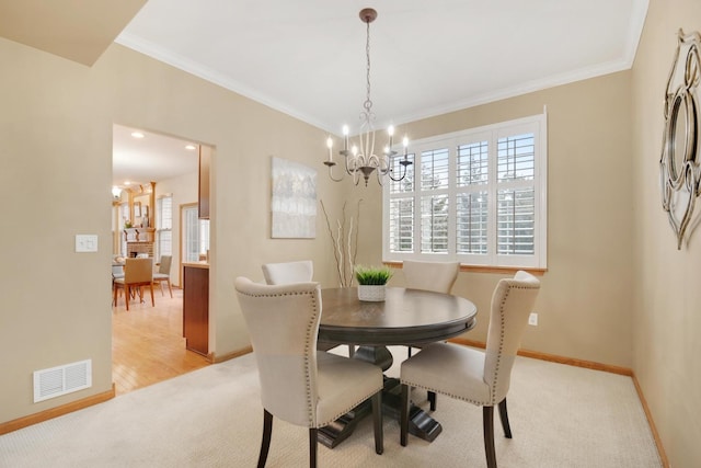 dining space with ornamental molding, a healthy amount of sunlight, visible vents, and light colored carpet