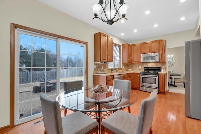 dining room featuring a notable chandelier, recessed lighting, visible vents, light wood-type flooring, and baseboards