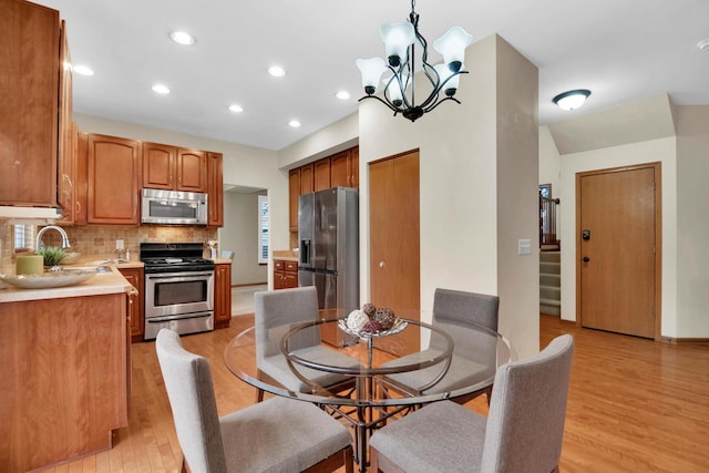 dining room with light wood-style flooring, stairs, a notable chandelier, and recessed lighting