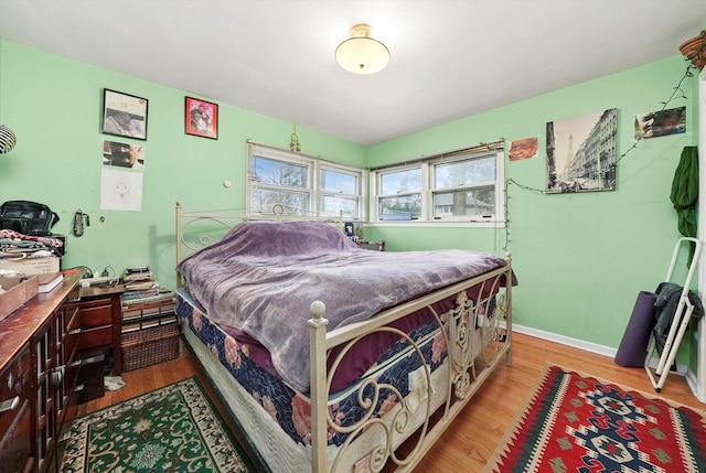 bedroom with light wood-style floors and baseboards