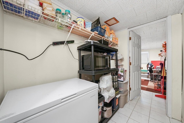 laundry area with light tile patterned floors