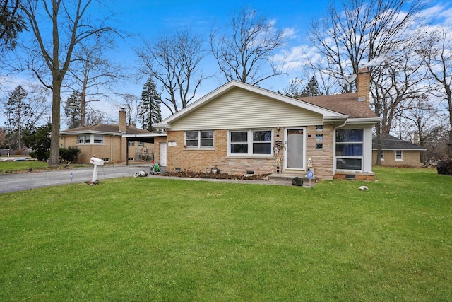 view of front of home with entry steps, aphalt driveway, brick siding, crawl space, and a chimney