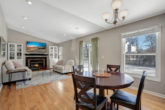 dining area featuring lofted ceiling, a healthy amount of sunlight, and light wood-style floors