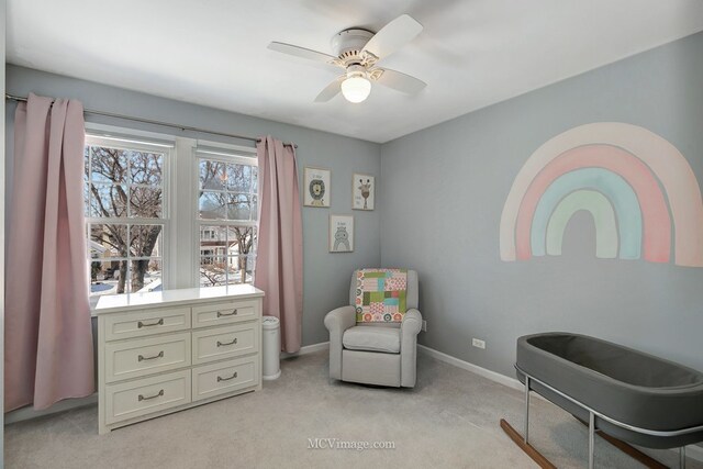 sitting room with light carpet, baseboards, and a ceiling fan