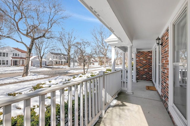 snow covered back of property with a residential view