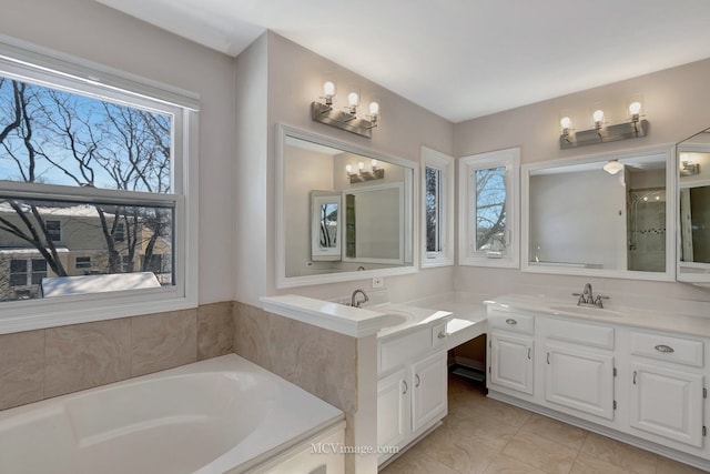 full bath featuring a bath, two vanities, and a sink