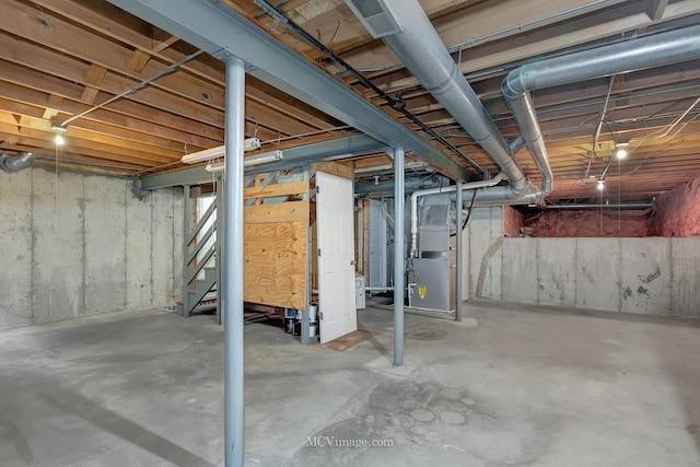 unfinished basement with heating unit and stairs