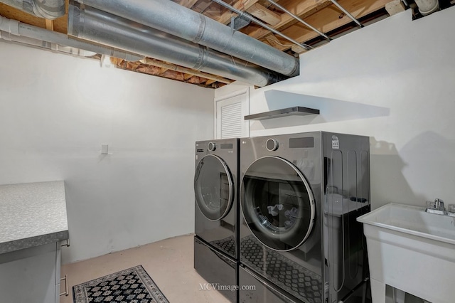 washroom featuring laundry area, a sink, and washing machine and clothes dryer