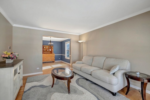 living area featuring a chandelier, crown molding, light wood-style flooring, and baseboards