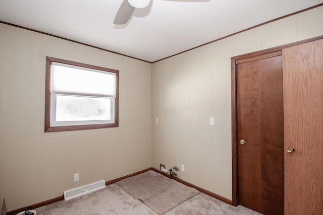 laundry area featuring ceiling fan, light carpet, visible vents, baseboards, and ornamental molding