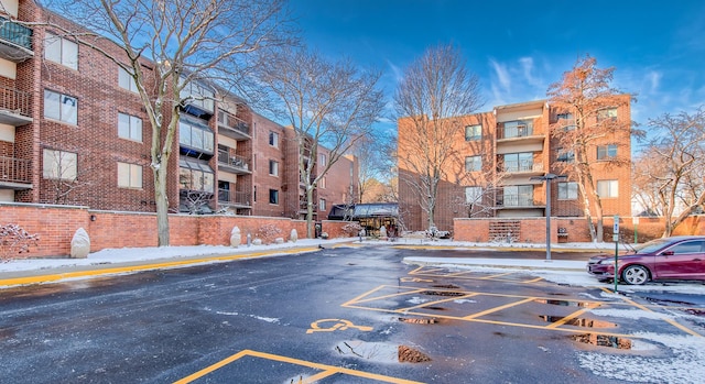 snow covered property with uncovered parking