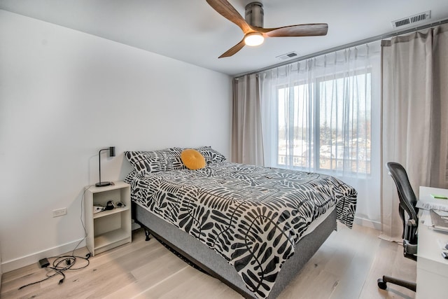 bedroom featuring light wood finished floors, visible vents, and baseboards